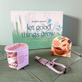 Limited edition gift boxes featuring a plant care guide, a seed starter kit, and pruning shears on a textured surface.