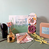 Limited edition gift box featuring a watering can, plant care tools, decorative items, and a growth-themed card.