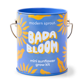 Bright blue tin can featuring yellow sunflower graphics, labeled "Bada Bloom Mini Sunflower Grow Kit" by Modern Sprout.