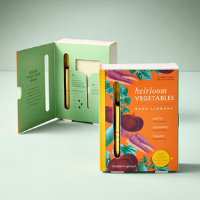Heirloom vegetables seed library book with colorful cover and seed storage tube, promoting home gardening.