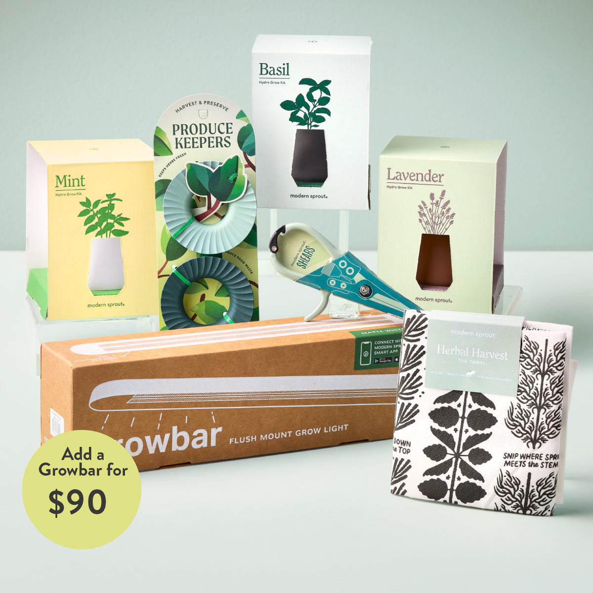 Hydroponic herb grow kits in green, white, and pastel boxes, with a grow light, tea towel, and plant accessories arranged ...