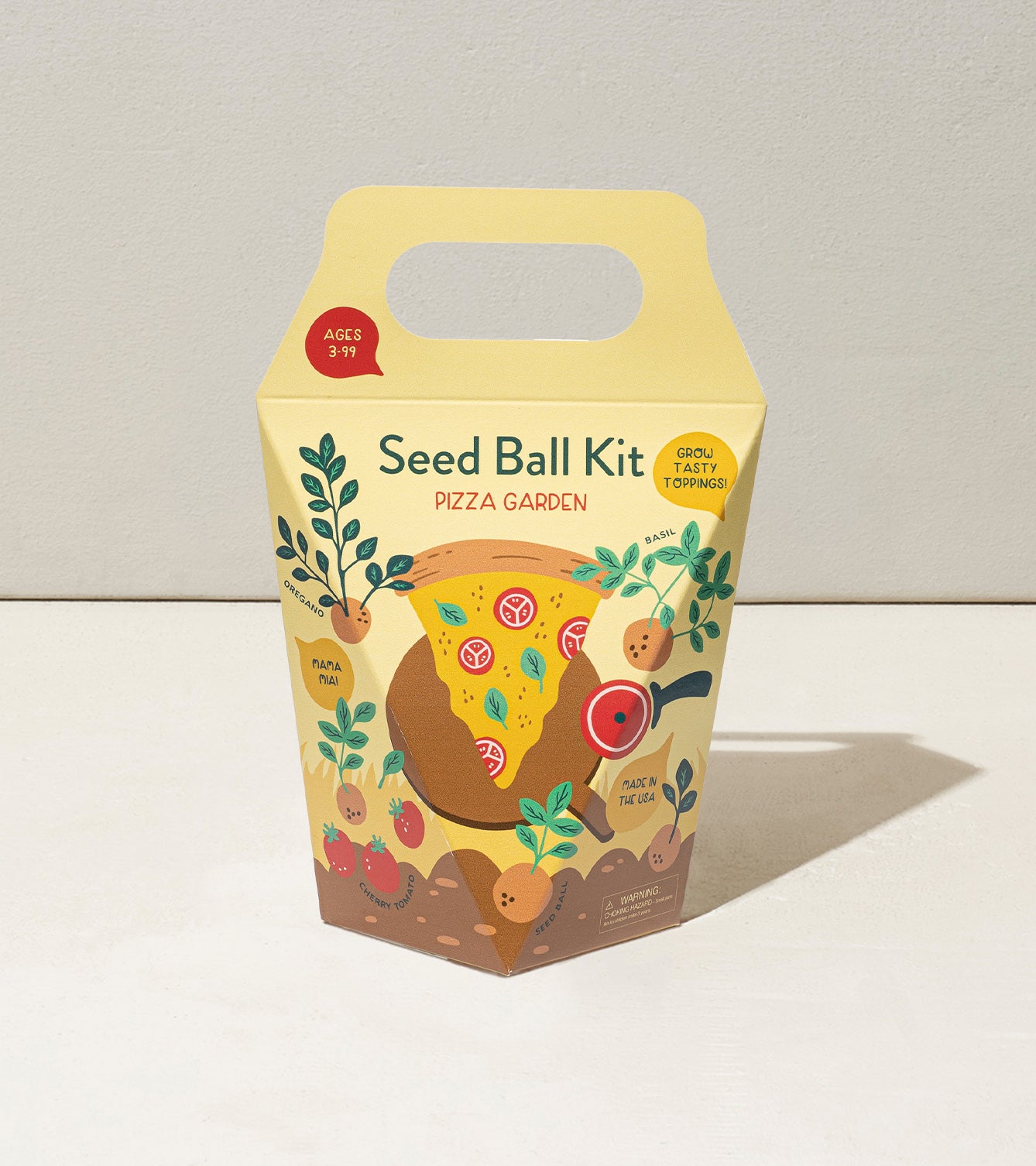 Colorful Seed Ball Kit packaging featuring a pizza garden theme with illustrations of vegetables and herbs.