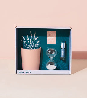 Mindful meditation kit featuring a pink planter with illustrated plants, an hourglass, and a calming essential oil.