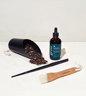 Botanical gift box set featuring a soil scoop, plant care serum, brush, and a planting tool, all designed for plant enthusiasts.