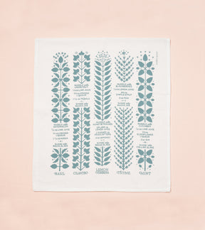Tea towel featuring botanical illustrations and recipes for basil, cilantro, thyme, and mint in teal on a white background.