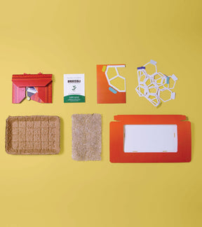 Microgreens Pop-Up Kit components including seed packet, growing medium, and pop-up planter on a yellow background.