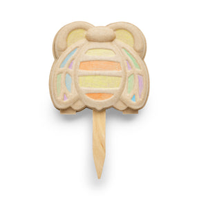 Colorful garden marker shaped like a bear, featuring pastel stripes and a wooden stake for plant identification.